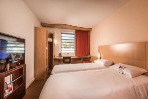 A bed or beds in a room at ibis Cannes Mandelieu