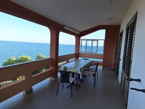 un balcon avec une table et des chaises et l'océan dans l'établissement Apartman Ksenija, à Lun