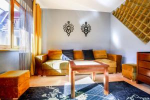 扎科帕内VisitZakopane - Mohito Apartment的客厅里有一张沙发和一张桌子。
