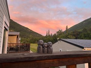 a porch with three figurines on the railing of a house at Camping White Rock in Castellane