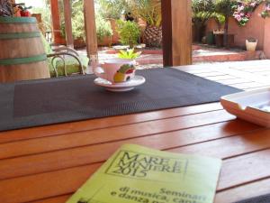 a cup of coffee sitting on a table with a book at Il Vigneto B&B in Gonnesa