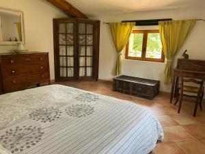 a bedroom with a bed and a dresser and a window at Camping White Rock in Castellane