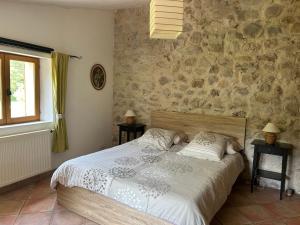 a bedroom with a bed and a stone wall at Camping White Rock in Castellane