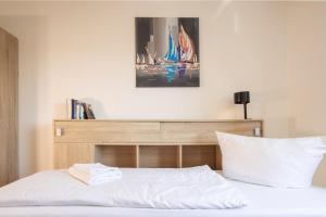 a bedroom with a bed with a wooden headboard at Naturpanorama am Bodensee - Zuhause mit Seeblick! in Tettnang +17 photos