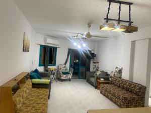 a living room with couches and chairs and a ceiling at Two bedroom Chalet in Golden Beach Ras Sedr Fully Air conditioned in front of the pool near the beach kids aqua kids areas family cafeteria in Ras Sedr