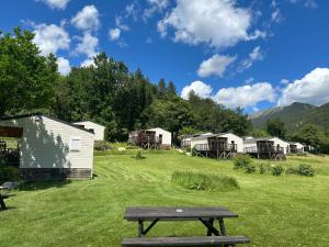 a picnic table in the middle of a field with houses at Camping White Rock in Castellane