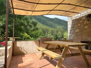 a wooden picnic table on a patio with a view at Camping White Rock in Castellane