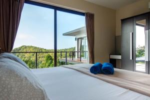 1 dormitorio con 1 cama grande y toallas azules. en Ocean View Villa Haad Salad, en Ko Pha Ngan 32 fotos más