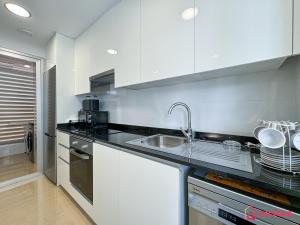 eine Küche mit weißen Schränken und einer Spüle in der Unterkunft Secreto Mediterráneo in Cabanes