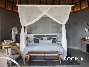 a bedroom with a bed with a canopy at Fifty-Five Mjejane in Hectorspruit