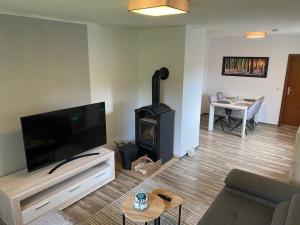 a living room with a flat screen tv and a stove at Ferienwohnung Plaue Auszeit mit Privatstrand und Bootsliegeplatz in Zislow