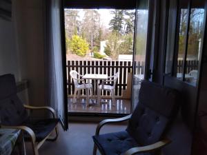 a room with a table and chairs on a balcony at Studio Barbotan in Barbotan-les-Thermes