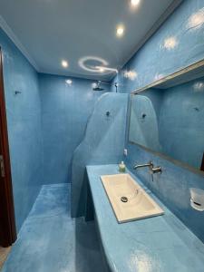 a blue bathroom with a sink and a mirror at Villa Bournous in Mesokhória +21 photos