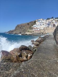 a beach with waves crashing on the rocks at Casa en Salobreña, La Caleta, a 200m de la playa con garaje privado in Salobreña