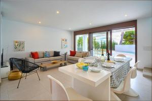 ein Wohnzimmer mit Tisch und Couch in der Unterkunft LA CALMA - Managed by Almarina in Moraira