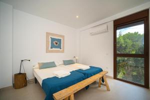 Schlafzimmer mit einem Bett mit einer Bank und einem Fenster in der Unterkunft LA CALMA - Managed by Almarina in Moraira + 29 Fotos
