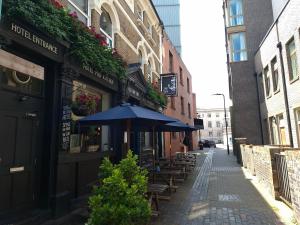un vicolo con tavoli e ombrelloni su una strada di Old Ship Inn Hackney a Londra