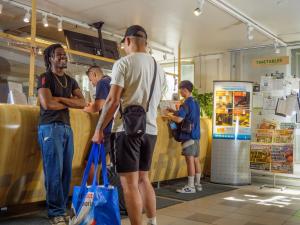 a group of men standing at a counter in a store at Eurohostel in Helsinki