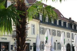 a building with white umbrellas in front of a palm tree at slot Ferienwohnung Schwetzingen in Schwetzingen