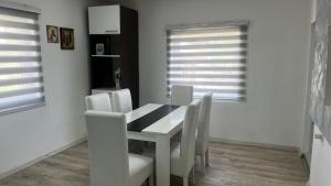 a dining room with a white table and white chairs at Čajića avlija in Obrenovac