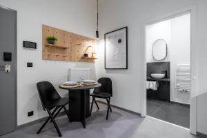 a dining room with a table and black chairs at HONEST Karlin in Prague