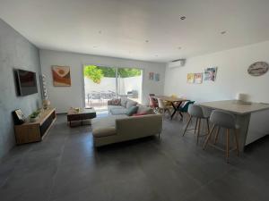 a living room with a couch and a table at Villa JOPI 3Ch piscine plage entierement climatisée in Le Grau-dʼAgde