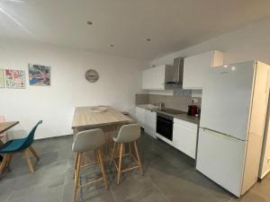 a kitchen with white cabinets and a table and chairs at Villa JOPI 3Ch piscine plage entierement climatisée in Le Grau-dʼAgde