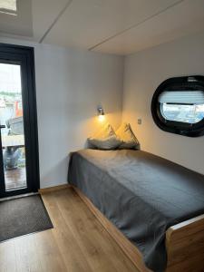 MaasbommelHausboot KOMET Luxus und Natur pur max 5 Pers的一间有窗户的小房间里的一张床