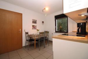 eine Küche und ein Esszimmer mit Tisch und Stühlen in der Unterkunft Ferienanlage Dröse, Haus 8a - Fewo 7 rolli-gerecht in Fulgen