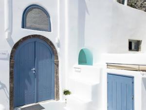 a blue door on the side of a white building at Oinos Luxury Suites in Foinikiá