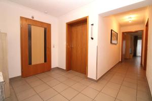 ein Flur mit zwei Türen und Fliesenboden in der Unterkunft Ferienanlage Dröse, Haus 8a - Fewo 8 rolli-gerecht in Fulgen