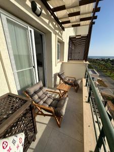 eine Veranda mit zwei Stühlen und einem Balkon mit Aussicht in der Unterkunft Студия в комплексе Thalassa с видом на горы in Elea