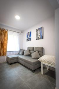 a living room with a couch and a bed at Przystań Lubniewice - Małe Domki in Lubniewice