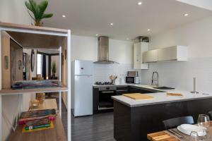 une cuisine avec des armoires blanches et un réfrigérateur blanc dans l'établissement OIQIA • Escale, à Blois