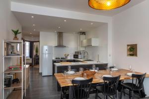 une cuisine et une salle à manger avec une table et des chaises en bois dans l'établissement OIQIA • Escale, à Blois