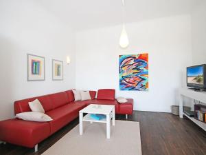 a living room with a red couch and a table at Jagdschloß zu Hohen Niendorf Fewo 6 in Hohen Niendorf