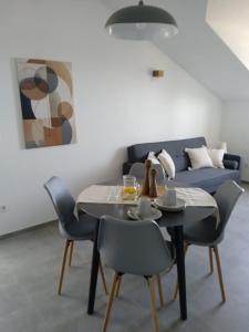 jadalnia ze stołem, krzesłami i kanapą w obiekcie Apartmani Nila w mieście Sveta Nedelja