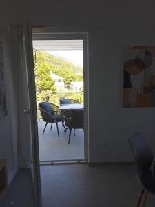 drzwi prowadzące na patio ze stołem i krzesłami w obiekcie Apartmani Nila w mieście Sveta Nedelja