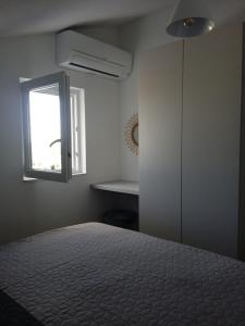 sypialnia z łóżkiem i oknem w obiekcie Apartmani Nila w mieście Sveta Nedelja +36 zdjęć