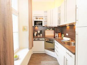 a kitchen with white cabinets and a sink at Jagdschloß zu Hohen Niendorf Fewo 4 in Hohen Niendorf