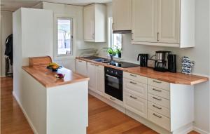 a kitchen with white cabinets and a wooden counter top at Two-Bedroom Holiday Home In Yngsjo in Yngsjö