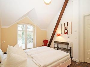 una camera da letto con un letto bianco e una finestra di Jagdschloß zu Hohen Niendorf Fewo 18 ANNA LUISE a Hohen Niendorf