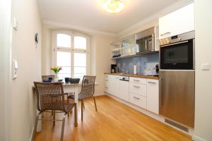a kitchen with a table and chairs and a refrigerator at Jagdschloß zu Hohen Niendorf Fewo 13 in Hohen Niendorf +30 photos