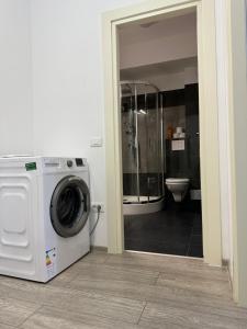 a washing machine in a bathroom with a toilet at RS Q Studio in Iaşi