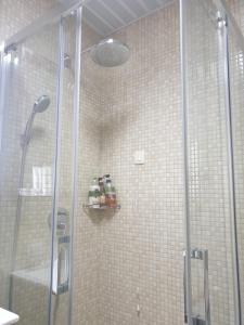 une douche avec une porte vitrée dans une salle de bain dans l'établissement AVAbys apartman, à Pržno