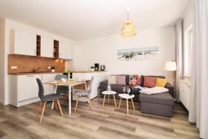 a living room with a table and a kitchen at Ostseeresidenz Appartements Wischuer Fewo 23 in Wischuer