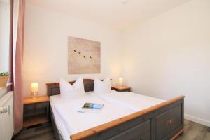 a bedroom with a bed with white sheets and two tables at Ostseeresidenz Appartements Wischuer Fewo 23 in Wischuer