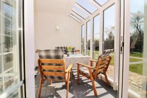 un patio con 2 sedie, un tavolo e finestre di Ostseeresidenz Appartements Wischuer Fewo 16 a Wischuer Altre 37 foto