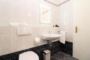 un bagno bianco con lavandino e WC di Ostseeresidenz Appartements Wischuer Fewo 16 a Wischuer