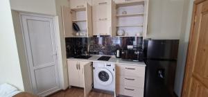 a kitchen with a black refrigerator and a washing machine at Karakum Batumi in Batumi
